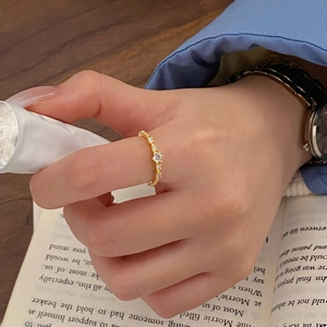 Détail d'une bague élégante plaquée or avec zircone portée dans un cadre lifestyle