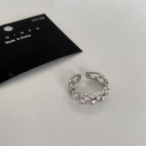 Détail d'une bague ouverte argentée avec pavé de zircons et découpes géométriques