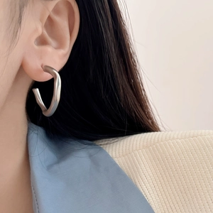 Minimalist irregular matte C-shaped silver earrings worn by model for a modern aesthetic