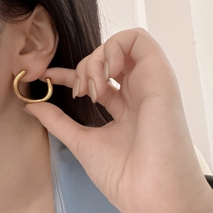 Irregular matte gold C-shaped hoop earrings with a textured finish for a minimalist look