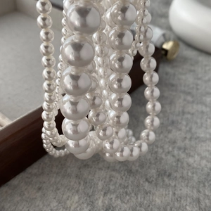 Macro shot of layered white round pearl necklaces with elegant luster and varying sizes