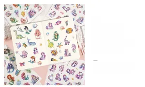 Close-up of glitter ocean stickers with mermaid and animal patterns on a notebook