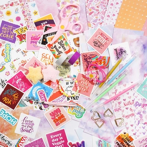 Dettaglio del kit per scrapbooking fai-da-te con adesivi, penne e forbici rosa creative