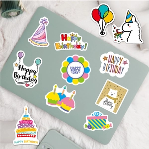 Close-up of colorful cartoon birthday stickers on a laptop over a soft white rug