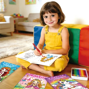 Little girl coloring mermaid and princess books with colored pencils at home