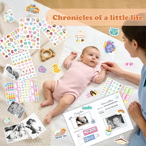 Close-up of baby milestone stickers and hardcover memory book on a soft white rug