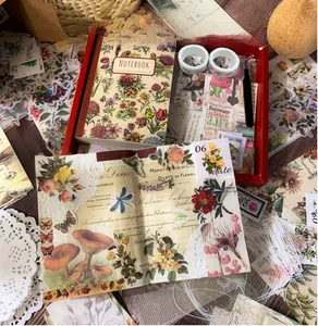 Detailed view of aesthetic vintage scrapbooking kit with floral stickers and notebook