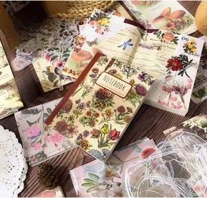 Flat lay of A6 floral aesthetic notebook with vintage botanicals on rustic wood
