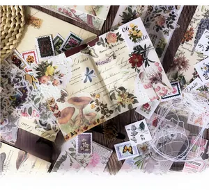 Flat lay of vintage scrapbooking kit featuring floral stickers on a dark wood background