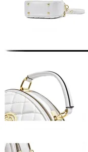 Detail view of the quilted white bag base with protective gold-tone metal feet and stitching