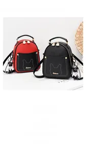 Detailed macro of a mini cross-pattern leather backpack with cat ear stitching and bear charm