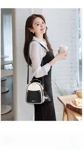 Chic monochrome crossbody backpack with panda ear detail and bear charm on a model