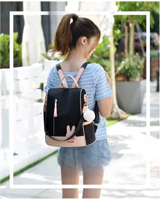 Outdoor shot of a woman wearing a black and pink oxford backpack with rabbit ear patterns