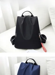 Detail des wasserdichten Nylon-Rucksacks mit robustem Stoff und rot-weißem Zierband-Anhänger