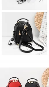 Detailed close-up of mini Saffiano leather backpack with gold heart zippers and bear charm