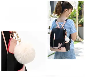 Detail of oxford backpack featuring pink rabbit ear accents and a plush pompom keychain
