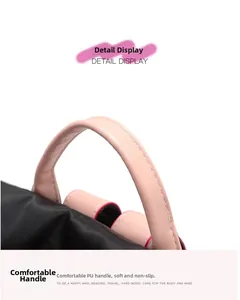 Detail of pink PU leather handle with white stitching on durable nylon backpack
