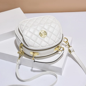 Elegant white quilted round crossbody bag with gold hardware on minimalist background