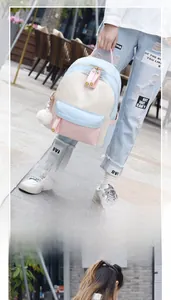 Detail view of a color-block casual backpack with pompom decor and multiple pockets