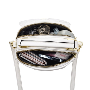 White quilted crossbody bag with dual zipper compartments showing daily storage capacity
