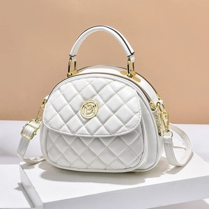 White quilted shell bag with gold hardware and chain strap on a geometric stand