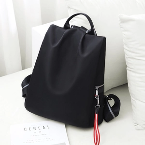 Minimalistischer schwarzer Nylon-Rucksack mit Zierband, präsentiert in Lifestyle-Umgebung