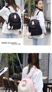 Detail view of stylish oxford cloth backpack with cute pompom charm and adjustable straps