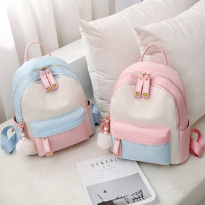 Women's stylish oxford canvas backpack in pink and blue with cute fur ball pendant