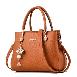 Sac à main marron en cuir litchi avec doubles poignées, bandoulière et pendentif perle