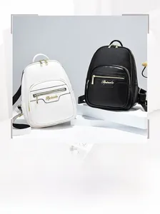 Detail view of stylish PU leather backpacks with gold metal zips and brand plaque