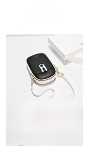 Detail of minimalist black and white phone bag with gold hardware and slim shoulder strap