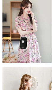 Detail of a chic black and beige crossbody phone bag with gold hardware on a floral dress