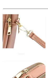 Detail of light brown leather phone bag with gold metal hardware and detachable strap