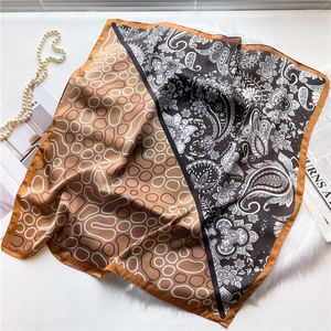 Detail of square silk scarf with paisley pattern and geometric pebble textures