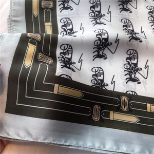Detail of luxury silk scarf with vintage carriage print and decorative metal buckle pattern