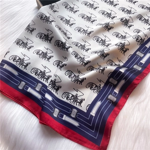 Macro shot of ivory silk scarf showing luxury horse carriage print and soft texture