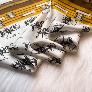 Close-up of luxury silk scarf with vintage carriage print on white faux fur background