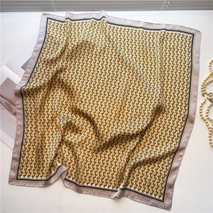 Detailed view of geometric pyramid pattern silk scarf with elegant yellow and grey borders