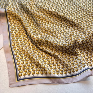 Close-up of geometric triangle pattern silk scarf with elegant drape and satin luster