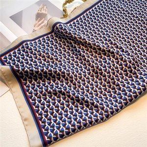 Detail of silk-like geometric triangle pattern scarf with contrasting border finish