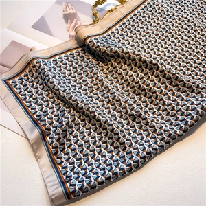 Detailed view of geometric pyramid silk scarf with blue and orange borders and texture