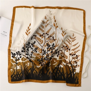 Détail macro du foulard en soie avec imprimé floral de pissenlit et fini satiné