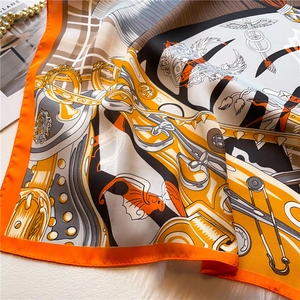 Close-up of luxury silk scarf with equestrian horse print on white faux fur background