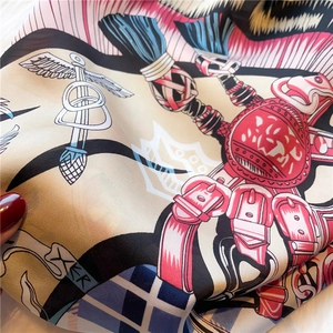 Close-up of vintage silk scarf featuring intricate crest patterns and rich textures