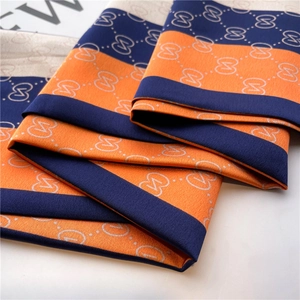 Détail d'un foulard en soie à motif géométrique S orange et bleu avec une texture premium