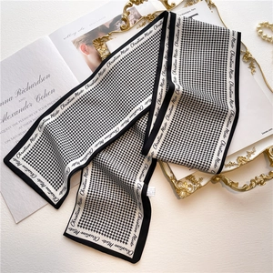 Classic black and white houndstooth skinny silk scarf on an elegant vintage tray