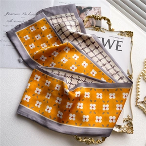 Close-up of double-sided silk scarf with yellow floral and brown houndstooth patterns