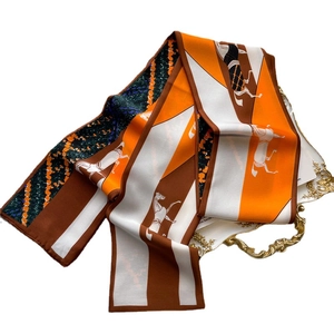 Élégant foulard en soie orange avec imprimé cheval sur un plateau décoratif blanc