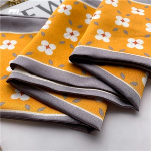 Detail of yellow floral silk scarf with petal pattern and elegant grey border texture