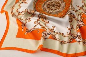 Detail of satin floral scarf showing smooth silk texture and baroque orange pattern
